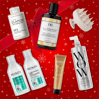 Collection of high-end hair care products including Olaplex, Redken, and Color Wow arranged on a red holiday-themed background.