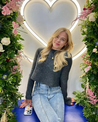 Illuminated heart-shaped light fixture surrounded by pink and white floral arrangements.