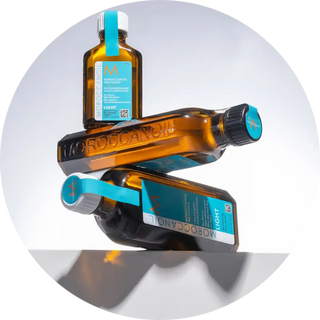 Amber glass bottles of Moroccan oil hair treatment stacked in a balanced arrangement.