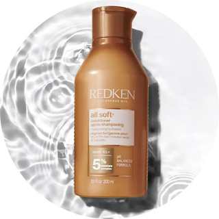 Bronze-colored Redken All Soft conditioner bottle.