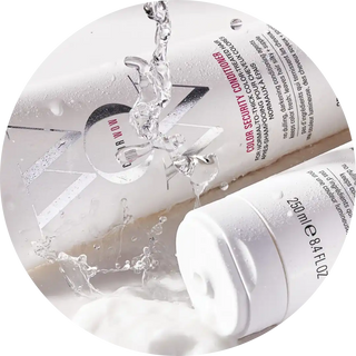 Clear water splashing onto a white cosmetic product container.