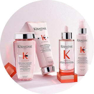 Collection of pink Kérastase hair care products in bottles and tubes.