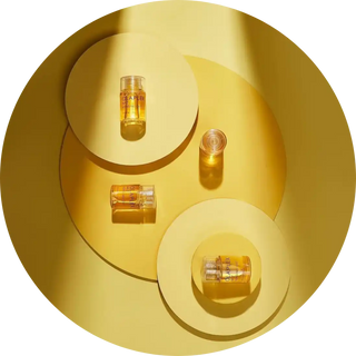 Glass vials or bottles containing golden liquid arranged in a yin-yang pattern.