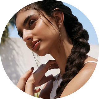 A long dark braid with loose wisps of hair against a profile pose.