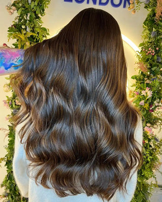 Long, wavy dark brown hair with glossy, flowing curls.