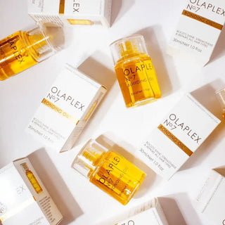 Olaplex No. 7 Bonding Oil bottles and product boxes arranged in a flatlay composition.