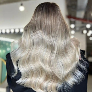 Platinum blonde hair styled in glossy, flowing waves.