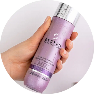 Purple System Professional color-protecting shampoo bottle held in a hand.