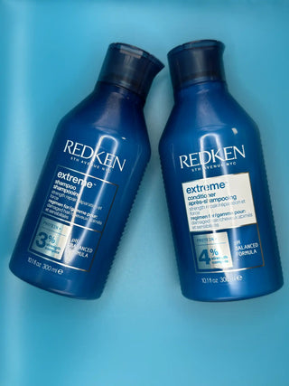 Two blue Redken Extreme shampoo bottles.