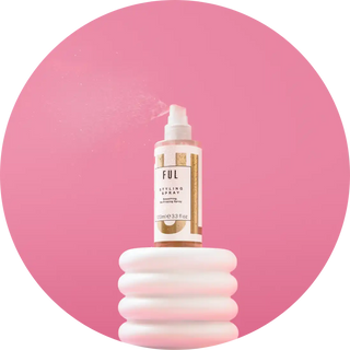 White bottle of FUL beauty product perched on a ribbed white pedestal.