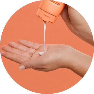 White liquid soap being dispensed onto an open palm.